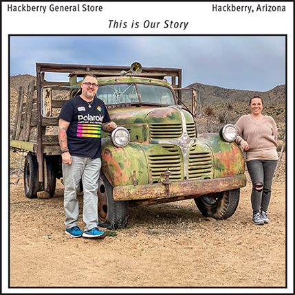 A Photograph of Mike & Aleah Perry standing next to a rusty truck at Hackberry General Store in Hackberry, Arizona on Route 66.